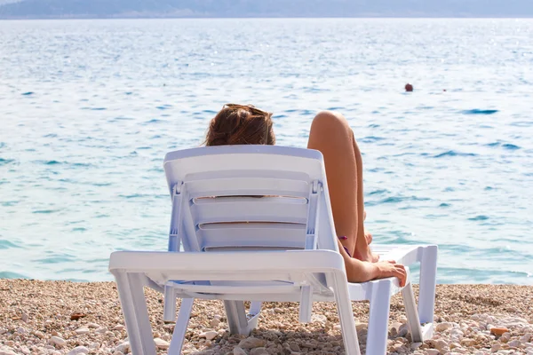 Menina descansando em uma cadeira de praia e observando o mar. Turismo, recreação — Fotografia de Stock