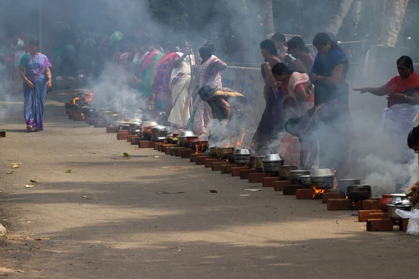 KOVALAM, KERALA, INDIA, 1 апреля 2015 г.: Некоторые женщины-преданные участвуют в церемонии Понгала, где богу предлагается варёный рис, приготовленный в черных горшках — стоковое фото