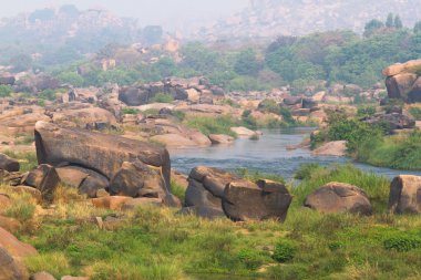 Hampi Köyü Tungabhadra nehir çayır. Manzara su, palm, rock, taşlar ile. Türkiye, İstanbul