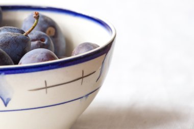 Mavi Erik çorba tabağına yalan. Menekşe renkli taze arka planı