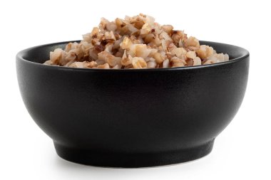 Beyazda izole edilmiş siyah bir seramik kasede kızartılmış karabuğday. Düşük açı.