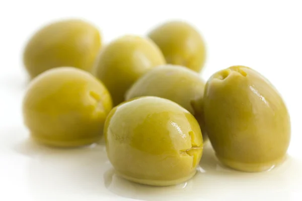 Pitted green olives with brine on white. — Stock Photo, Image