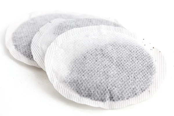 Round English tea bags with dried tea leaves. — Stock Photo, Image