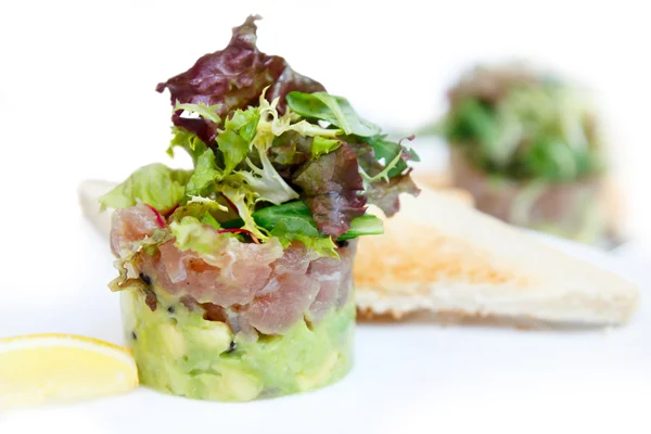 Tonno e tartaro di avocado con pane tostato e limone . — Foto Stock