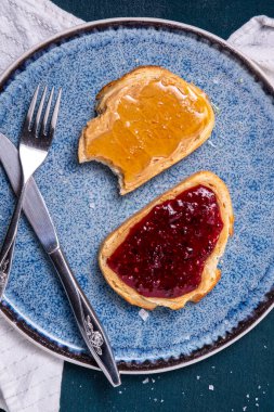 Bal, ahududu reçeli ve tuzlu tost üzerine fıstık ezmesi.
