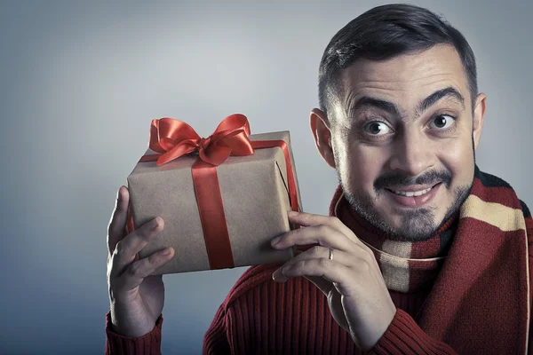 Uomo allegro scuotendo la confezione regalo e sorridendo . — Foto Stock