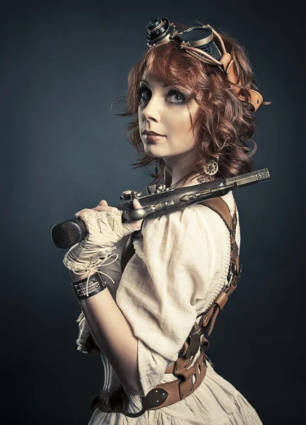 Hermosa chica steampunk pelirroja con pistola mirando a la cámara — Foto de Stock