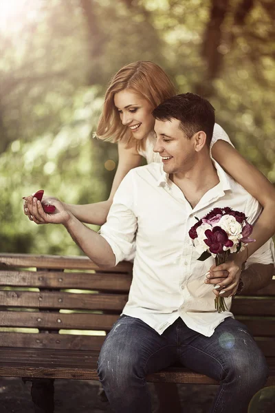 Conceito de amor e casamento. Jovem casal feliz sentado no parque — Fotografia de Stock