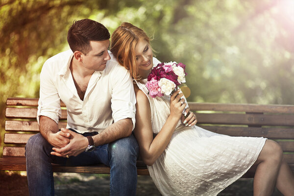  Young beautiful couple sitting in the park and man proposing wo