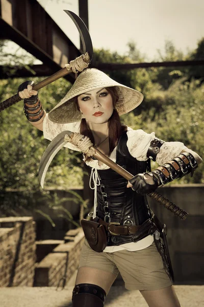 Beautiful attrctive female warrior holding two swords and fighti — Stock Photo, Image