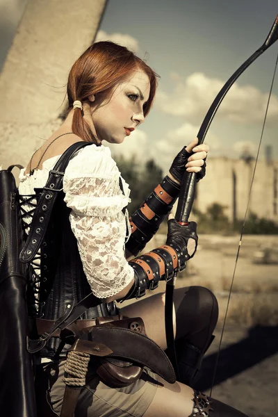 Attractive severe redhair woman warrior holding in her hands bow — Stock Photo, Image