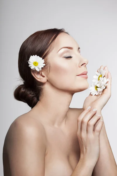 美しい女性は、カモミールの花を呼吸します。. — ストック写真