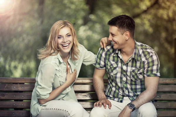 Relatie concept. Jonge vrolijke paar zitten in het park — Stockfoto