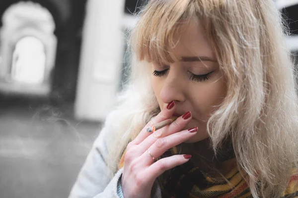 Grave Jovem Loira Fundo Cinza Fumando Com Olhos Fechados — Fotografia de Stock