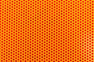 Yuvarlak delikleri ve deseni olan metal turuncu ağ.