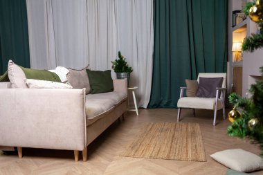 İç mekan, kanepe ve sandalye yeşil perdelerin arkasında.