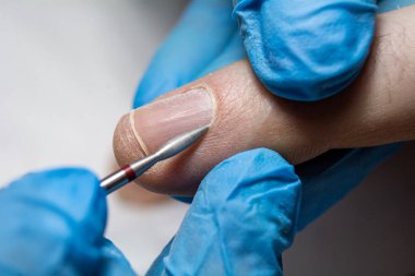 Güzellik salonunda erkek manikürü. Manikür makinesi olan erkekler için profesyonel manikür. Kozmetik uzmanı tırnak derisini kesip çıkarıyor. yakın plan.