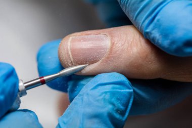 Güzellik salonunda erkek manikürü. Manikür makinesi olan erkekler için profesyonel manikür. Kozmetik uzmanı tırnak derisini kesip çıkarıyor. yakın plan.