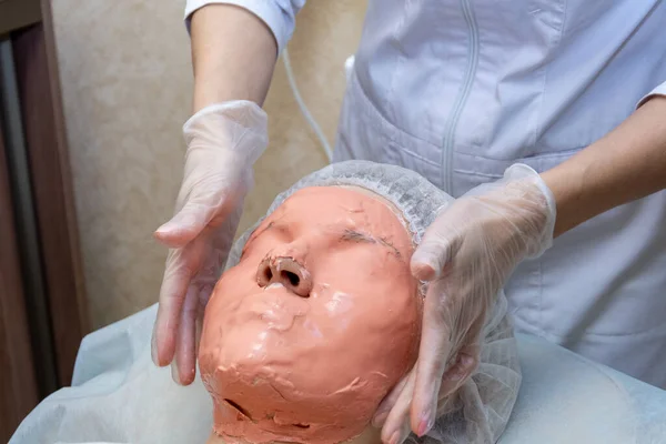 Een vrouw met een alginaatmasker op haar gezicht. schoonheidsbehandelingen. — Stockfoto