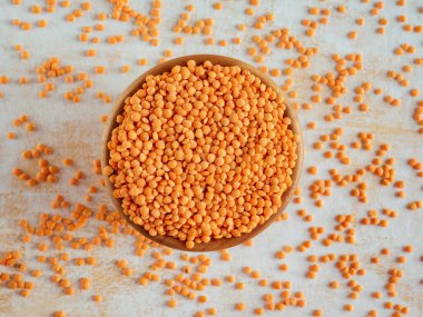 Sağlıklı beslenme ve beslenme. Beyaz ahşap arka planda bir kase çiğ kırmızı mercimek. Üst Manzara. Düz yatıyordu. Masoor Dal veya Canadian Orange Lentils. Vejetaryen süper yemeği..