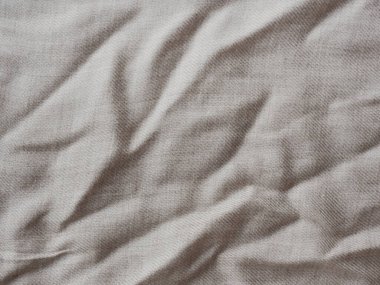 Tasarım için minimalist arka plan. Kırışık bej kumaş dokusu. Ayrıntılı yakın çekim. Kırsal, eski, buruşuk pamuk kumaş. Rahat bir kumaş. Dalgalı doğal malzemeyi katlar.