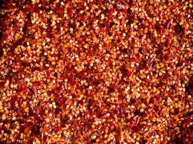 Crushed red chilli pepper used as background. Cayenne pepper, dried chilli. It is a popular spicy condiment for Mexican dishes. Top view.