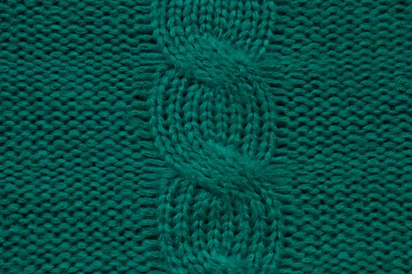 Wool hand-knitted or machine knitting pattern with braids. Knit warm green sweater or scarf. Cozy dark emerald blanket background. Fabric texture close up. Comfortable style cloth. — Stock Photo, Image