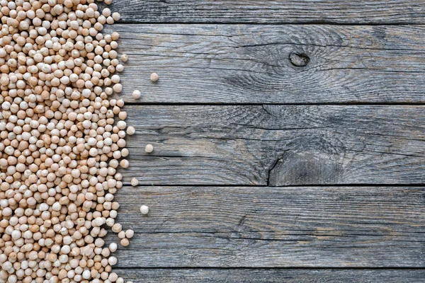 Uncooked dried legume chickpeas or garbanzo bean on wooden background. Vegetarian super food. Healthy eating and dietary. Indian, Mediterranean and Middle Eastern cuisine. Top view — Stockfoto