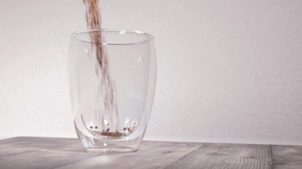 白い背景の前の空のサーモカップ 粒状のコーヒー粉がカップに注ぎ込まれゆっくりとした動き — ストック動画