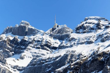 Gün boyunca parlak güneş ışığı ve güzel mavi bulutsuz gökyüzü ile etkileyici Saentis dağı, telekomünikasyon ve radyo iletim kulesi ile zirvede görülebilir, gündüz yakın görüş,