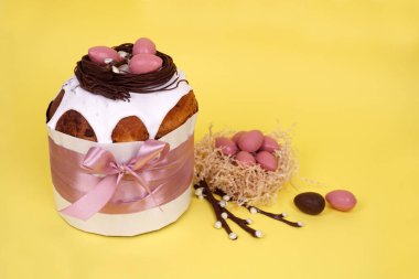 Paskalya pastası, çikolatalı yumurta ve renkli bir arka planda tavşan olan güzel bir Paskalya kompozisyonu..