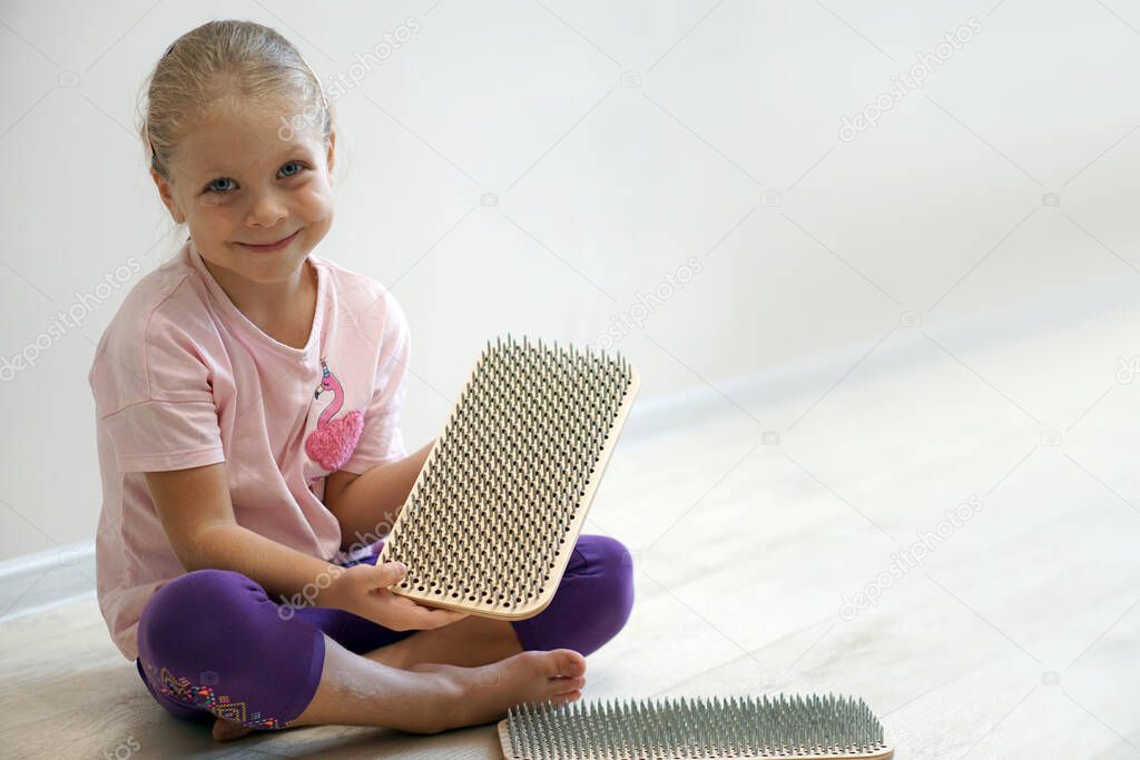 The sadhu's board is in the hands of a beautiful little yogini girl. Children's yoga, meditation and practice.