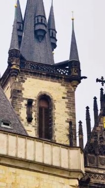 Prag Gotik Kilisesi, Eski Şehir Katedrali 'nin altın haçlı taş kuleleri dikey 4K dikey 4K dikey B-rulo görüntüleri bulutlu gökyüzü