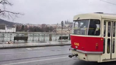 Prag, Çek Cumhuriyeti 11 Şubat 2026: Şehir merkezindeki tarihi binaların yakınlarındaki kaldırım taşı caddesinde kırmızı ve beyaz tramvaylar seyahat ediyor.