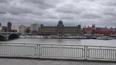 Prag, Çek Cumhuriyeti 13 Şubat 2026: Vltava Nehri kıyısı tarihi binalar, tur tekneleri ve setten görülen dramatik bulutlu gökyüzü. Sadece editör kullanımı.