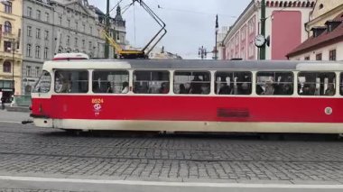 Prag, Çek Cumhuriyeti 19 Şubat 2026: Şehir merkezinde tarihi renkli binalar bulunan iki kırmızı ve beyaz tramvay birbirlerini geçiyor. Sadece editör kullanımı.