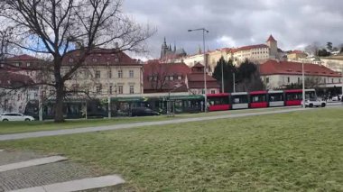 Prag, Çek Cumhuriyeti 24 Şubat 2026: Parlak bir kış günü öğleden sonra Charles Köprüsü 'nü geçen bir turist topluluğu, kaldırım kaldırımının üzerindeki süslü kaidelerin üzerinde duran büyük Barok taş heykellerinin her iki tarafında da yer aldı..