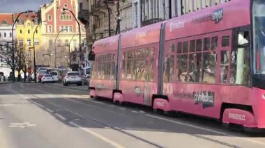 Prag, Çek Cumhuriyeti 24 Şubat 2026: Etkileyici bir kış sabahı, gösterişli neoklasik taş cephesi olan Vltava seti üzerindeki görkemli Ulusal Tiyatrosu 'nun önünden uzun, kırmızı ve beyaz bir tramvay geçiyor