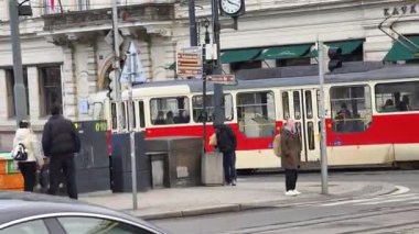 Prag, Çek Cumhuriyeti 24 Şubat 2026: Cesur, çok renkli, beyaz ve kırmızı bir tramvayla çarpıcı bir modern tramvay, Vltava nehir kenarı boyunca kameraya doğrudan yaklaşıyor