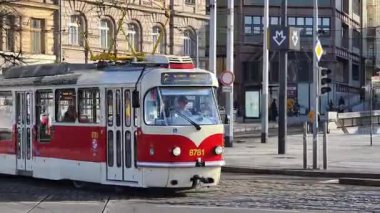 Prag, Çek Cumhuriyeti 24 Şubat 2026: Cesur, çok renkli, beyaz ve kırmızı bir tramvayla çarpıcı bir modern tramvay, Vltava nehir kenarı boyunca kameraya doğrudan yaklaşıyor