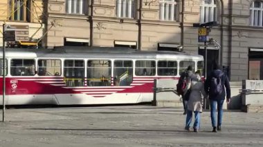 Prag, Çek Cumhuriyeti 24 Şubat 2026: Cesur, çok renkli, beyaz ve kırmızı bir tramvayla çarpıcı bir modern tramvay, Vltava nehir kenarı boyunca kameraya doğrudan yaklaşıyor