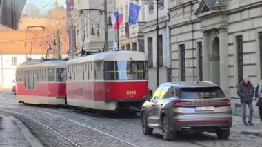 Prag, Çek Cumhuriyeti 25 Şubat 2026: Modern ve klasik tramvaylar tarihi caddelerde ve Bohem başkentinin sembolik meydanlarında seyahat ederek Prag Şatosu, Ulusal Tiyatro ve Dansçı Ev 'in de aralarında bulunduğu tarihi yerleri geçmektedir. Sadece editör kullanımı