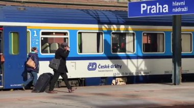 Prag Ana Tren İstasyonu 'ndaki platformda, Orta Avrupa' nın en yoğun ulaşım merkezlerinden birinin günlük atmosferini gösteriyor. Sahne, platformlar boyunca hareket eden yolcuların karakteristik mimarisini yakalar.
