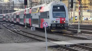 Prag Ana Tren İstasyonu 'ndaki platformda, Orta Avrupa' nın en yoğun ulaşım merkezlerinden birinin günlük atmosferini gösteriyor. Sahne, tarihi terminalin, aktif demiryolu operasyonlarının, yolcuların karakteristik mimarisini yakalıyor.