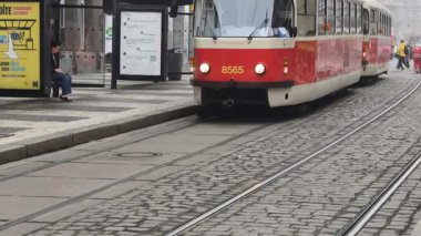 Prag, Çek Cumhuriyeti 27 Şubat 2026: Klasik kırmızı tramvay 4K yavaş çekimde şehir kavşağında kameraya yaklaşırken çekildi. Bu 4K hisse senedi görüntüsü herhangi bir Prag editör projesi için tam olarak ihtiyacınız olan şey.