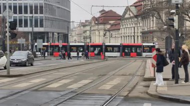 Prag, Çek Cumhuriyeti 27 Şubat 2026: Modern alçak tabanlı tramvay Old Town Meydanı yakınlarındaki 4K yavaş çekimde tarihi mimarinin yanından süzülerek geçti. Bu 4K görüntülerinde modern eklemli bir Prag tramvayı sergileniyor