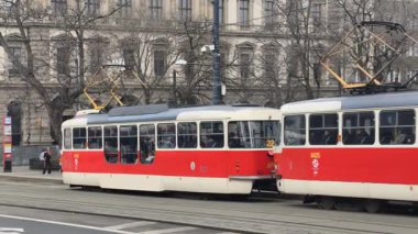 Prag, Çek Cumhuriyeti 27 Şubat 2026: Klasik kırmızı tramvay 4K yavaş çekimde şehir kavşağında kameraya yaklaşırken çekildi. Bu 4K hisse senedi görüntüsü herhangi bir Prag editör projesi için tam olarak ihtiyacınız olan şey.