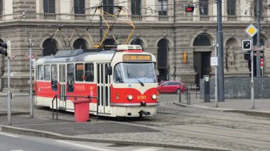 Prag, Çek Cumhuriyeti 27 Şubat 2026: Klasik kırmızı tramvay 4K yavaş çekimde şehir kavşağında kameraya yaklaşırken çekildi. Bu 4K hisse senedi görüntüsü herhangi bir Prag editör projesi için tam olarak ihtiyacınız olan şey.
