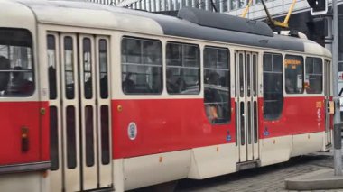 Prag, Çek Cumhuriyeti 27 Şubat 2026: Klasik kırmızı tramvay 4K yavaş çekimde şehir kavşağında kameraya yaklaşırken çekildi. Bu 4K hisse senedi görüntüsü herhangi bir Prag editör projesi için tam olarak ihtiyacınız olan şey.