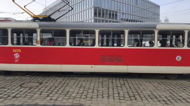 Prag, Çek Cumhuriyeti 27 Şubat 2026: Klasik kırmızı tramvay 4K yavaş çekimde şehir kavşağında kameraya yaklaşırken çekildi. Bu 4K hisse senedi görüntüsü herhangi bir Prag editör projesi için tam olarak ihtiyacınız olan şey.